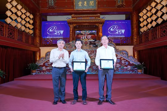 ông Nguyễn Minh Hồng - Chủ tịch VDCA (bên trái) trao chứng nhận cho đại diện Bảo hiểm Việt Nam và Thông tấn xã Việt Nam