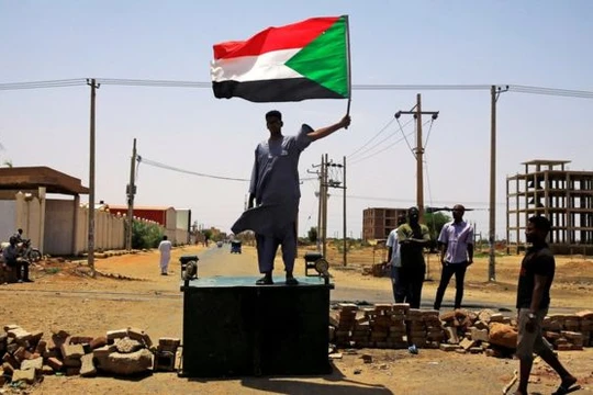 Một người biểu tình Sudan đứng trên hàng rào chắn ở Khartoum hôm thứ Tư (ảnh Reuters)