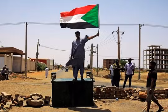 Một người biểu tình Sudan đứng trên hàng rào chắn ở Khartoum hôm thứ Tư (ảnh Reuters)