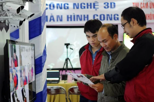 Khách tham quan nghe giới thiệu về thiết bị camera giám sát tại một triển lãm về thiết bị công nghệ