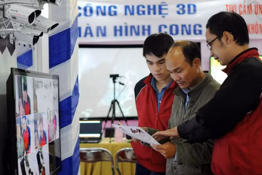 Khách tham quan nghe giới thiệu về thiết bị camera giám sát tại một triển lãm về thiết bị công nghệ