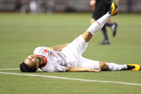 Quang Hải tỏ ra đau đớn sau khi va chạm với Irfan Fandi (ảnh: 24h.com.vn)