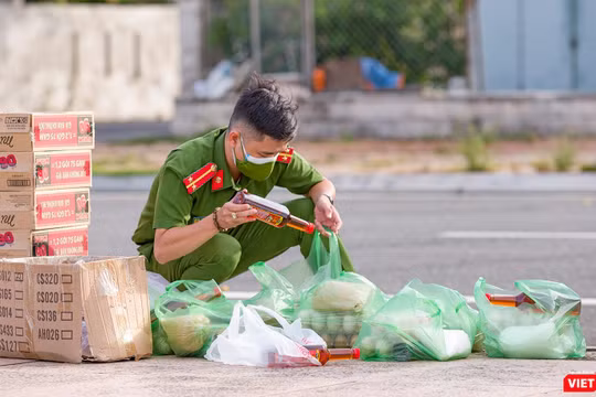 Chiến sĩ trẻ soát lại đơn hàng nhu yếu phẩm của người dân trước khi giao (Ảnh: Nghĩa Hiếu)