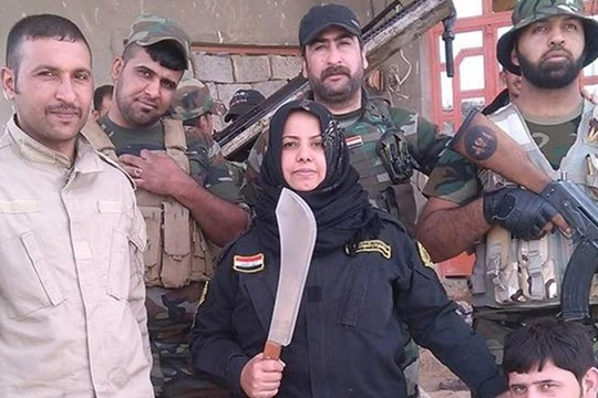 "Bà nội trợ" Wahida Mohamed Al-Jumaily đứng bên các chiến binh dưới quyền. (Nguồn: Independent).