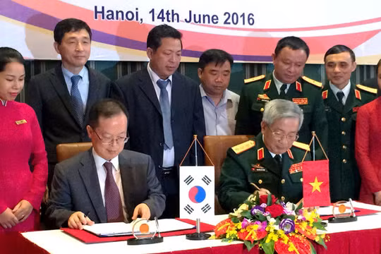 Thượng tướng Nguyễn Chí Vịnh (phải) và ông Chang Jae Yun ký kết biên bản hợp tác khắc phục hậu quả bom mìn sau chiến tranh - Ảnh: Q.TR..