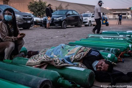 Một bệnh nhân COVID-19 và người nhà chờ đợi được thở oxy (Ảnh: Getty/Deutsche Welle).