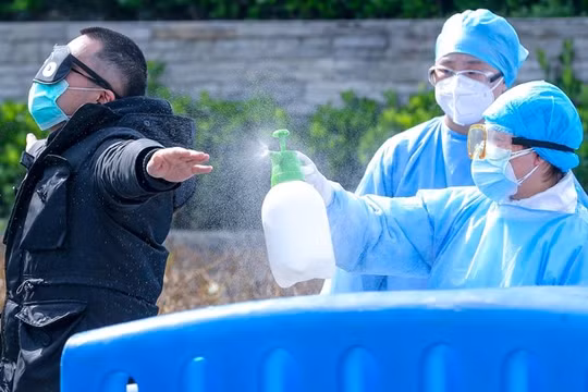 Nhân viên y tế ở Vũ Hán khử trùng bệnh nhân trước khi ra viện.(Ảnh Đông Phương).