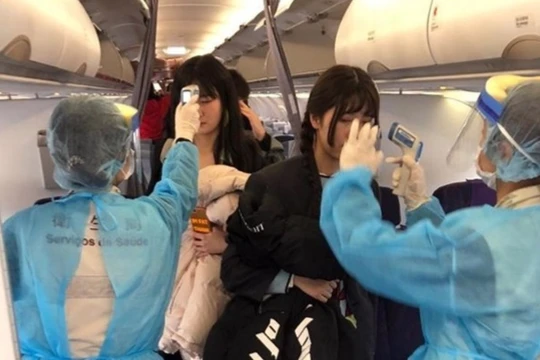 Đề phòng dịch bệnh lây lan, các nhân viên y tế sân bay Ma Cao lên máy bay đo thân nhiệt mọi hành khách trên chuyến bay từ Vũ Hán đến. (Ảnh: Đông Phương).