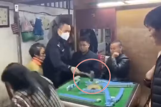 Người cảnh sát giận dữ dùng búa đập phá bàn mạt chược (Ảnh: Đông Phương)