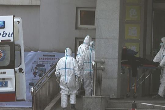 Các nhân viên y tế vận chuyển bệnh nhân vào khu vực điều trị cách ly ở Vũ Hán (Ảnh: Đa Chiều).