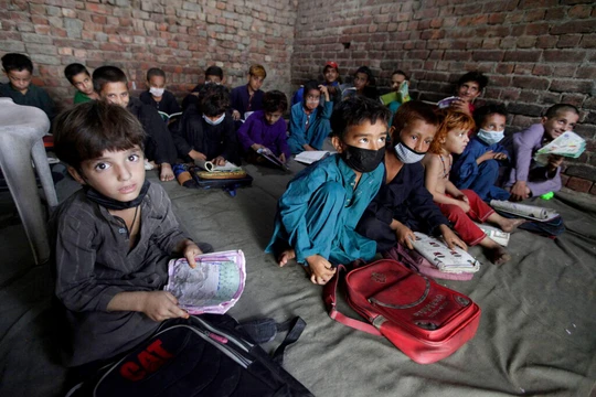 Trẻ em Afghanistan theo bố mẹ chạy sang Pakistan tị nạn (Ảnh Reuters).