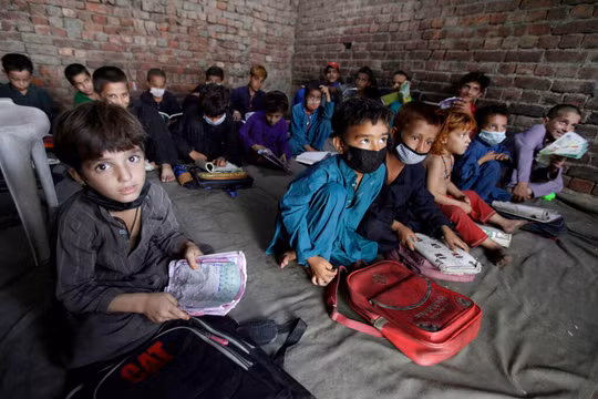 Trẻ em Afghanistan theo bố mẹ chạy sang Pakistan tị nạn (Ảnh Reuters).