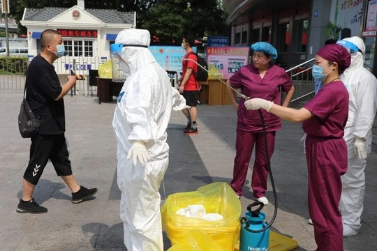 Nhân viên chống dịch tiến hành khử trùng các khu vực có người bị bệnh sinh sống ở thành phố Đại Liên (Ảnh: Đông Phương).