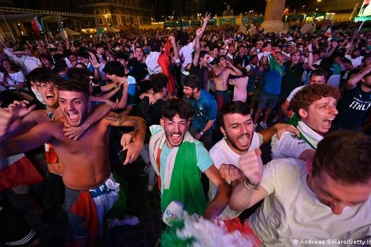 Tại một điểm xem công cộng ở Rome, người dân cổ vũ cho đội tuyển Italy, tình hình lây nhiễm COVID-19 trong trận đấu Italy-Tây Ban Nha vẫn chưa được biết (Ảnh: Deutsche Welle)