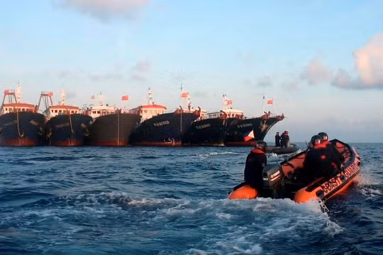 Xuồng của Cảnh sát biển Philippines tiếp cận các tàu Trung Quốc neo đậu trên bãi Ba Đầu (Ảnh: Reuters).