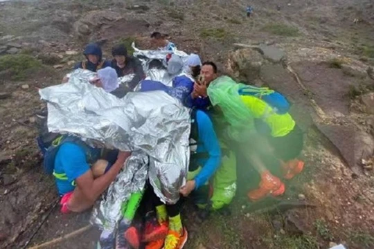 Các vận động viên ôm nhau truyền nhiệt sưởi ấm khi bị mưa đá, gió lạnh (Ảnh: toutiao).