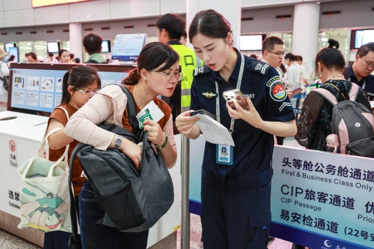 Nhân viên an ninh sân bay kiểm tra cục sạc dự phòng của hành khách. Ảnh: Sohu.