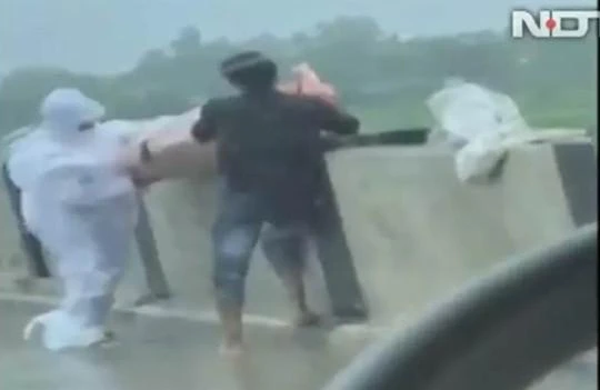 Hình ảnh một nhân viên y tế và người nhà ném thi thể bệnh nhân COVID-19 xuống sông trên NDTV (Ảnh: Chinatimes).