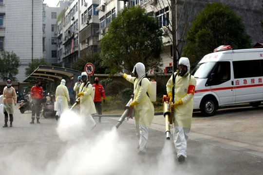 Các nhân viên y tế phun thuốc khử trùng trong các khu dân cư Vũ Hán (Ảnh: Reuters).