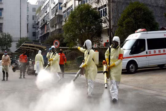Các nhân viên y tế phun thuốc khử trùng trong các khu dân cư Vũ Hán (Ảnh: Reuters).