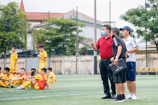 PTGĐ kiêm Giám đốc đào tạo trẻ Nguyễn Đình Nghĩa (áo đỏ) giờ đã có thể yên tâm sống bằng nghề. Ảnh CLB