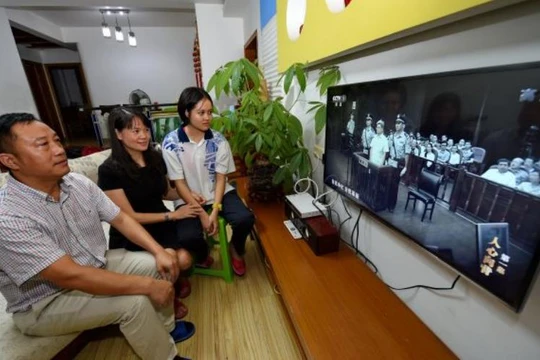 Người dân Trung Quốc xem xét xử các vụ án tham nhũng qua ti vi. Ảnh: Cankao