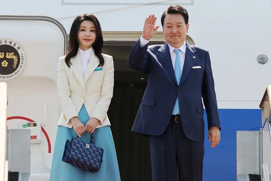 Tổng thống Yoon Suk-yeol (phải) và phu nhân lên máy bay rời Hàn Quốc. Ảnh: AFP