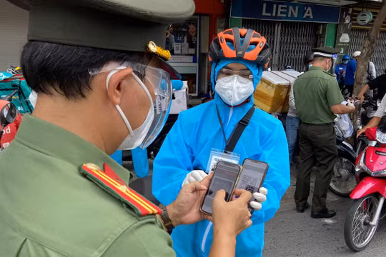 Cảnh sát kiểm tra mã QR của người dân tại chốt. Ảnh: VnExpress.