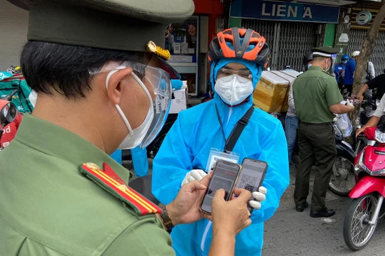 Cảnh sát kiểm tra mã QR của người dân tại chốt. Ảnh: VnExpress.