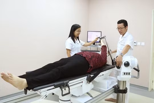 Nhóm bác sĩ của Bệnh viện Trung ương Quân đội 108 ứng dung robot hiện đại giúp bệnh nhân tập phục hồi chức năng khớp vai.