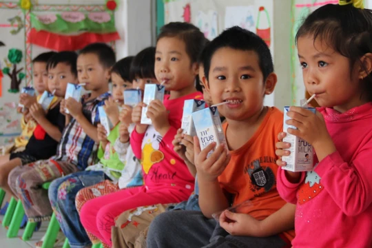 Các em nhỏ uống sữa tại trường mầm non.