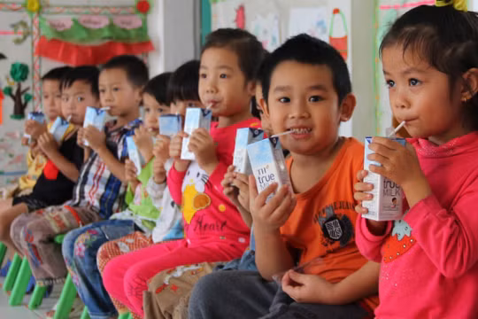 Các em nhỏ uống sữa tại trường mầm non.