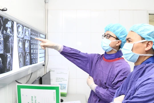 Bác sĩ xem kết quả chụp CT của người đàn ông trước khi thực hiện can thiệp nội mạch.