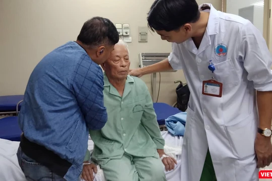 Bác sĩ Trịnh Tú Tâm và người thân của ông Đ. kiểm tra tình trạng sức khỏe của ông sau khi phẫu thuật bơm xi măng sinh học.