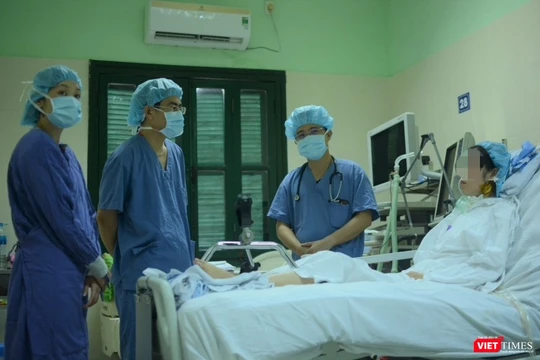 Bác sĩ giúp chị H. tập phục hồi chức năng tại giường (Ảnh: Quang Hùng)