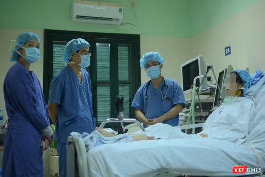 Bác sĩ giúp chị H. tập phục hồi chức năng tại giường (Ảnh: Quang Hùng)