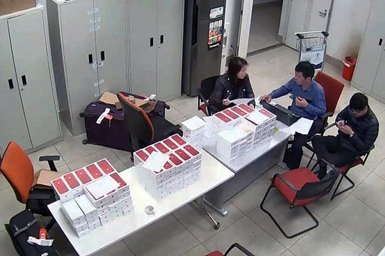 Lực lượng chức năng kiểm đếm số iPhone lậu bị phát hiện. (Ảnh: cơ quan chức năng cung cấp)