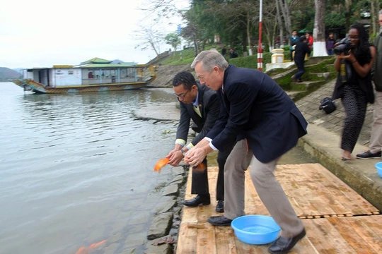 Đại sứ Mỹ Ted Osius và người bạn đời Clayton Bond cùng thực hiện nghi lễ thả cá chép trên sông Hương để tiễn đưa ông Công ông Táo về trời - Ảnh: Nguyên Linh