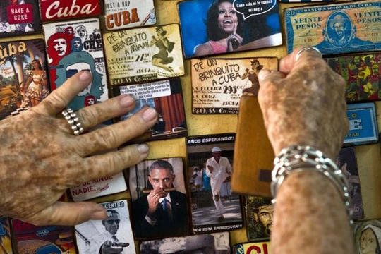 Một nghệ sĩ người Cuba trưng bày nhiều hình ảnh liên quan đến tổng thống Mỹ Barack Obama ở cửa hàng bán đồ lưu niệm tại thủ đô Havana, Cuba - Ảnh:AP