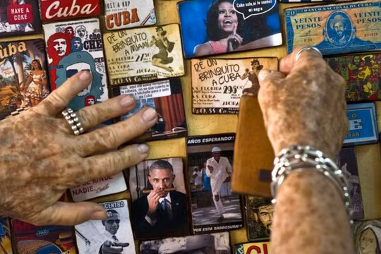 Một nghệ sĩ người Cuba trưng bày nhiều hình ảnh liên quan đến tổng thống Mỹ Barack Obama ở cửa hàng bán đồ lưu niệm tại thủ đô Havana, Cuba - Ảnh:AP