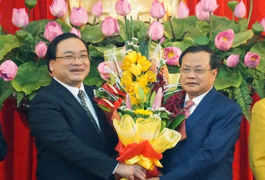 Ông Phạm Quang Nghị (phải) tặng hoa chúc mừng tân Bí thư Hà Nội Hoàng Trung Hải trong ngày nhậm chức