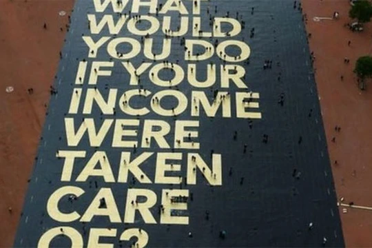 Tháng trước, những người ủng hộ đề xuất thu nhập cơ bản hàng tháng được đảm bảo ở Thụy Sỹ đã chuẩn bị một áp phích lớn với nội dung: "Các bạn sẽ làm gì nếu thu nhập của các bạn được chăm sóc?" - Ảnh: Reuters/BBC.