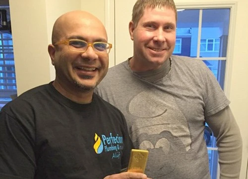 Hai ông thợ hàn và thỏi vàng nặng 1 kg - Ảnh: Alif Babul