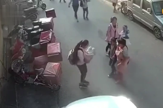 Cô bé nhanh chóng ôm lấy đứa trẻ và kiểm tra thương tích.