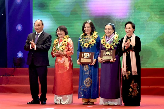 Thủ tướng Nguyễn Xuân Phúc (trái) và Nguyên Phó Chủ tịch nước Nguyễn Thị Doan (phải) tặng hoa cho các phụ nữ điển hình tiên tiến.