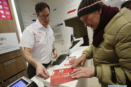 Một cụ ông tới mua tem Tết Đinh Dậu 2017 tại bưu cục Vancouver (Canada).