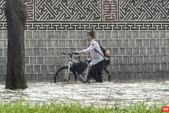 Một nữ sinh ướt hết quần áo khi di chuyển trên tuyến đường ngập sâu ở Hà Nội.