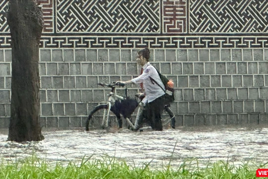 Một nữ sinh ướt hết quần áo khi di chuyển trên tuyến đường ngập sâu ở Hà Nội.