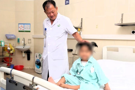 TS. Dương Đức Hùng - Giám đốc Bệnh viện Việt Đức - chia sẻ niềm vui với bé D.L chuẩn bị ra viện