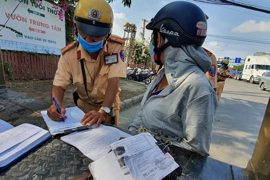 Một người phụ nữ bị CSGT phạt vì mang giấy tờ xe photo dù có chứng thực. Ảnh: Thanh Niên